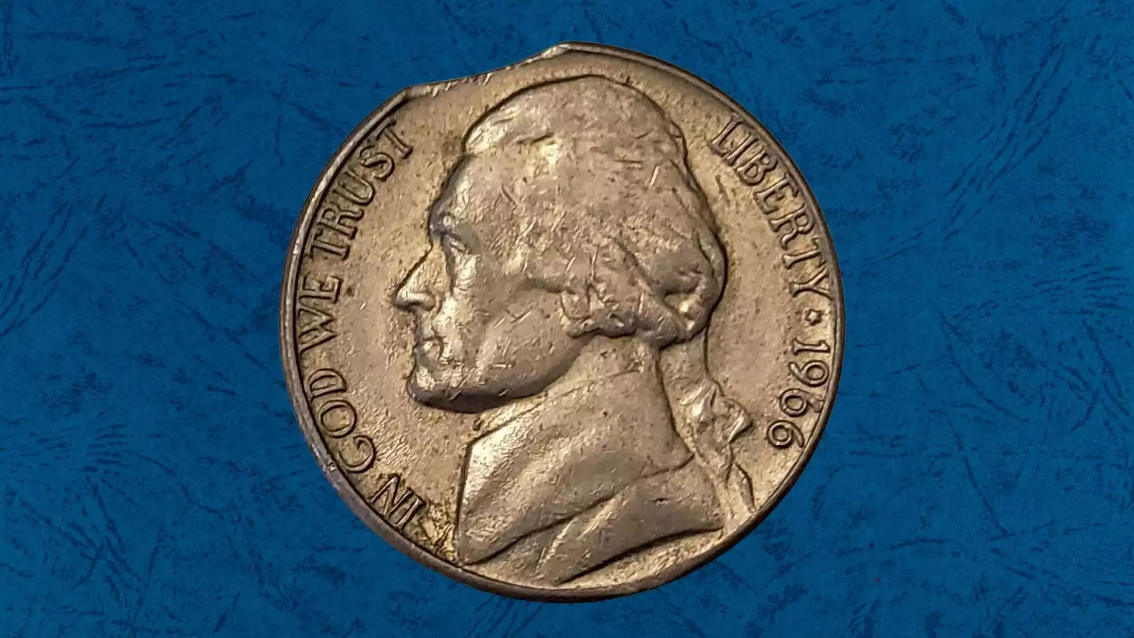 1966 nickel clipped planchet error showing curved crescent-shaped section missing from coin edge